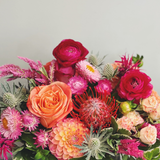 Bold and bright palette of flowers in orange, coral, hot pink, and fuschia.