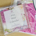 A floral 2027 wall calendar featuring twelve illustrations by local artist, Wickie Roland.