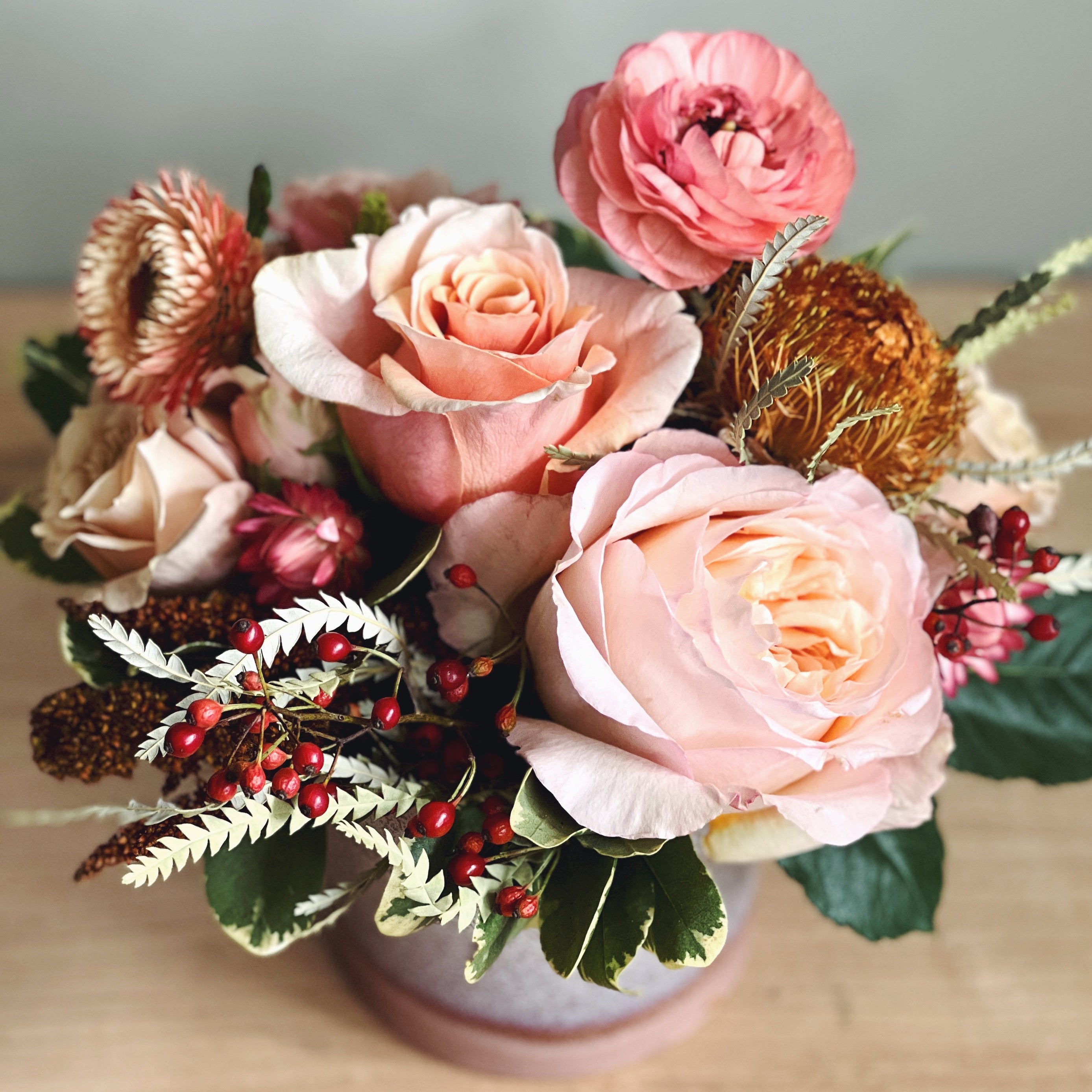Bouquet of soft fall colored flowers and natural textures including roses and ranunculus 