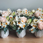 Multiple vases filled with a spring flowers like tulips, hyacinth and daffodils. 