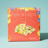 Box of Flower Co artisanal crackers with edible flowers on a light blue background