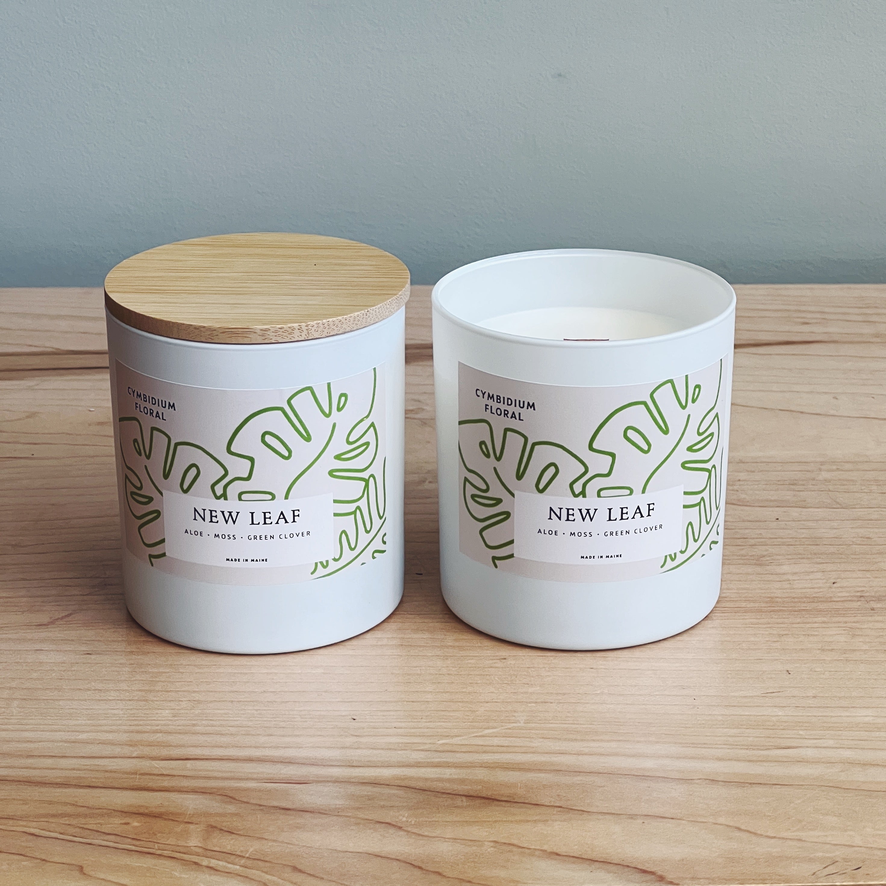 Wood wick coconut soy candles in New Leaf scent, featuring aloe, moss and green clover.