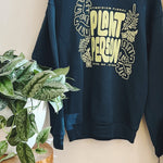 Deep green sweatshirt with 'Plant Person' text and plant designs on a light background