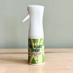 Air plant fertilizer spray bottle on a wooden surface with a plain background