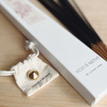 A box of Cymbidium Floral signature scented incense sticks featuring bergamot, orchid and white tea, accompanied by a brass incense holder 