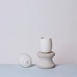 Two ceramic teacups on a light surface with a plain background