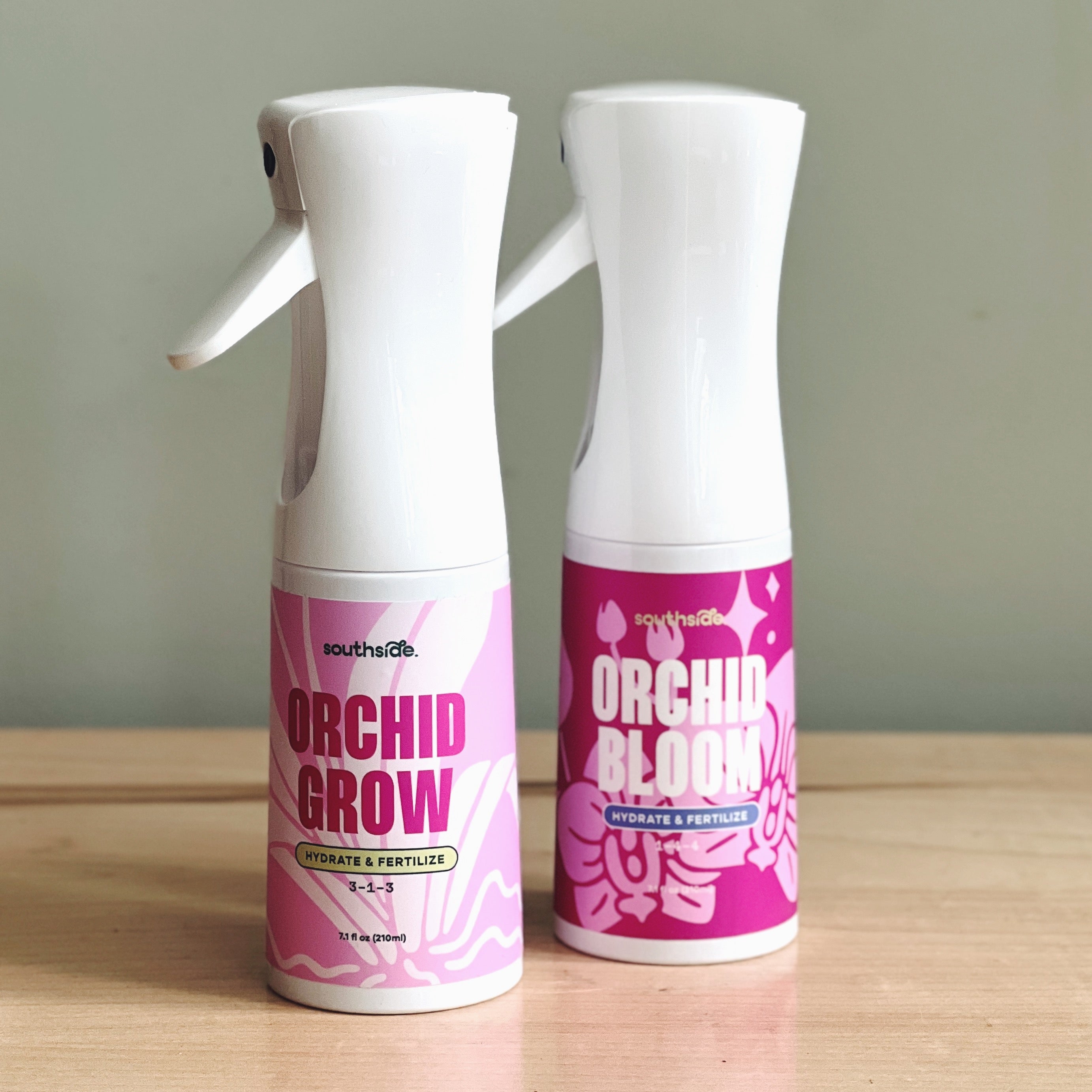 Two, Southside Orchid care fertilizer spray bottles on a wooden surface with a neutral background
