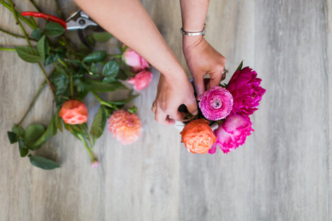 Close up photo of floral designer's hands cutting flowers.