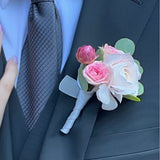 White and pink floral prom boutonniere on a dark suit jacket with a light blue shirt and gray tie.
