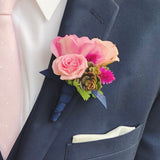 Pink floral prom boutonniere on a navy suit jacket