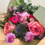 Bouquet of pink and purple flowers wrapped in paper. 
