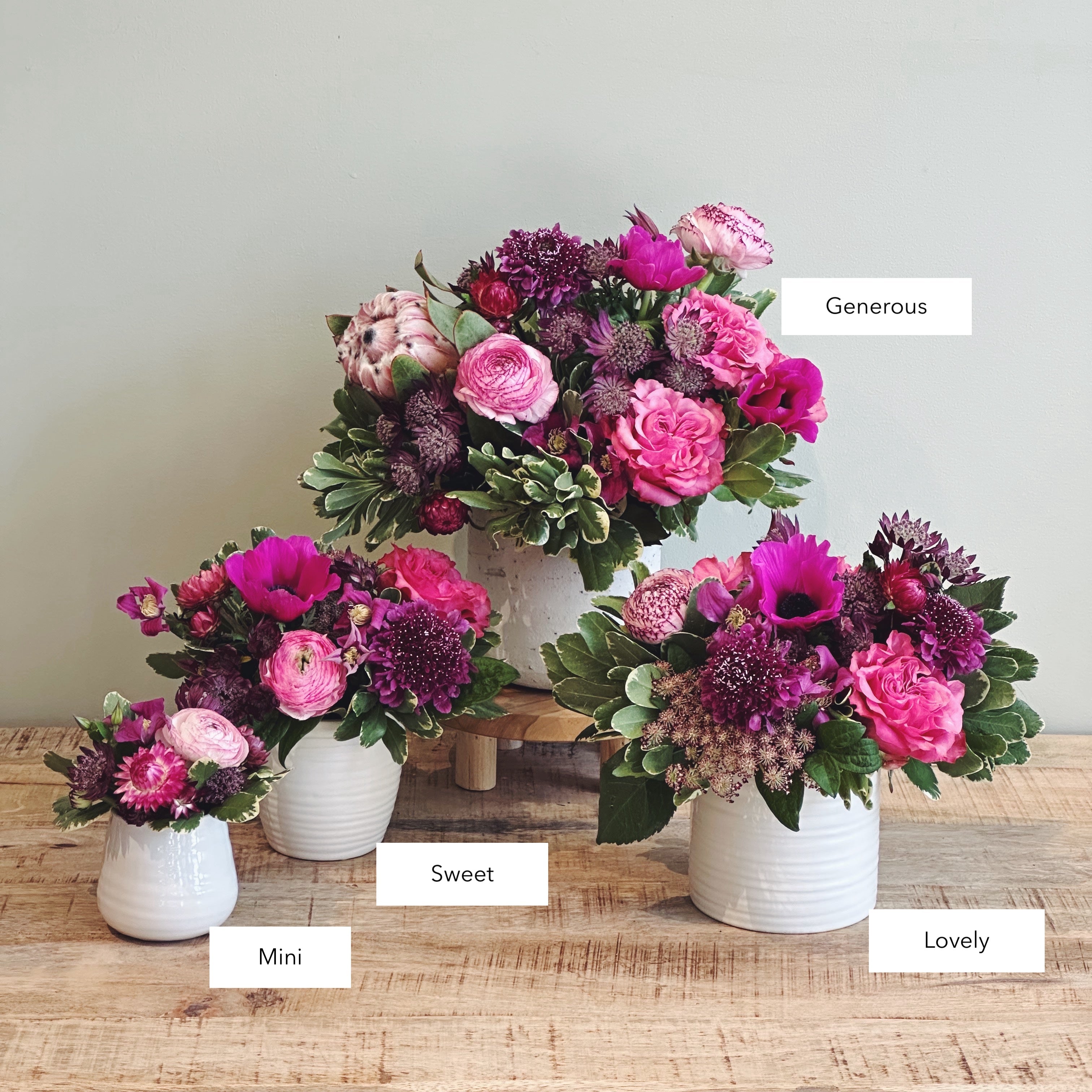 Three premium floral arrangements in rich jewel tones with sizes labeled 'Mini', 'Sweet', 'Lovely, and 'Generous'.