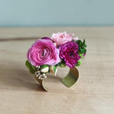 Floral prom cuff corsage with pink and purple flowers on a wooden surface