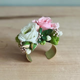 Floral prom cuff corsage with pink and white flowers on a wooden surface