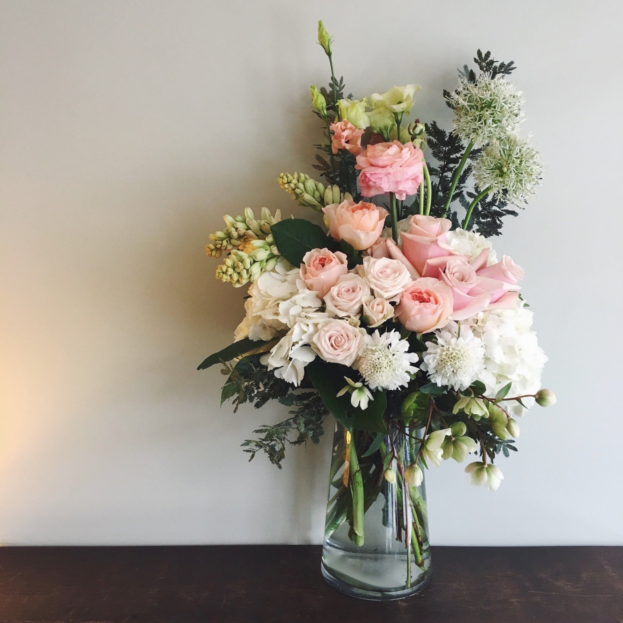 Tall soothing funeral arrangement for the service or home in white, and light pink.